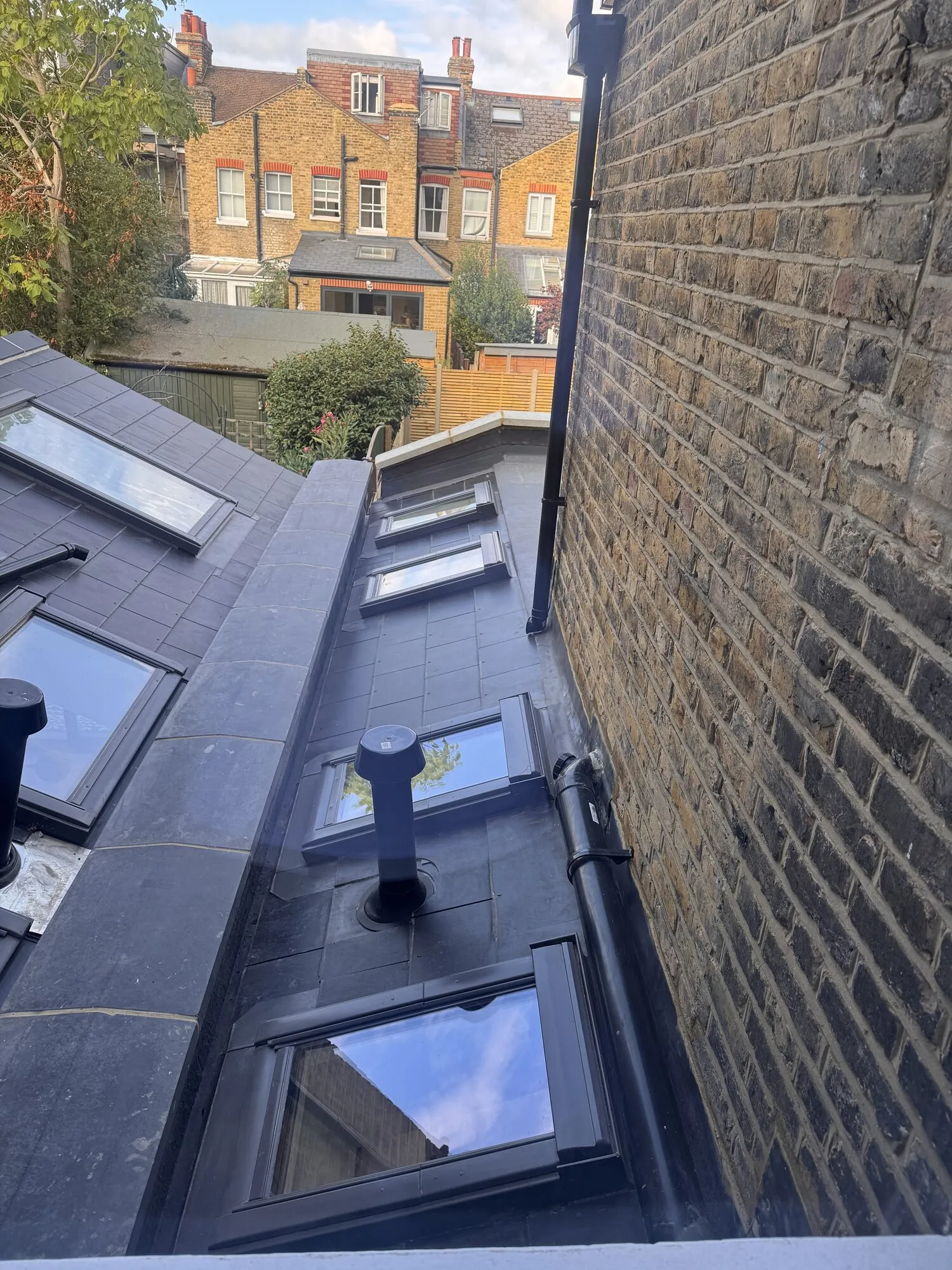New slate and lead rear roof with a run of rooflights, seen from above on an Earlsfield terrace