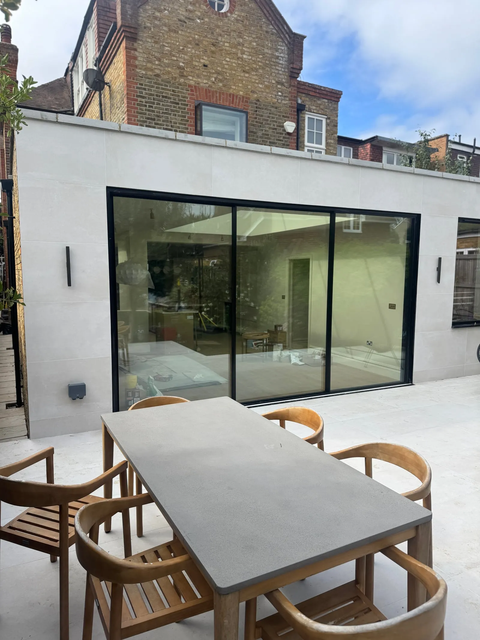 Completed extension with black-framed sliding doors onto a patio