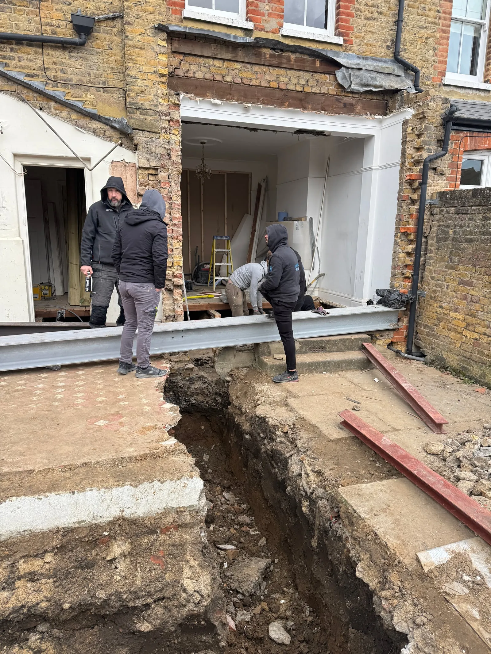 Excavation and structural steel being positioned on a rear extension, South West London