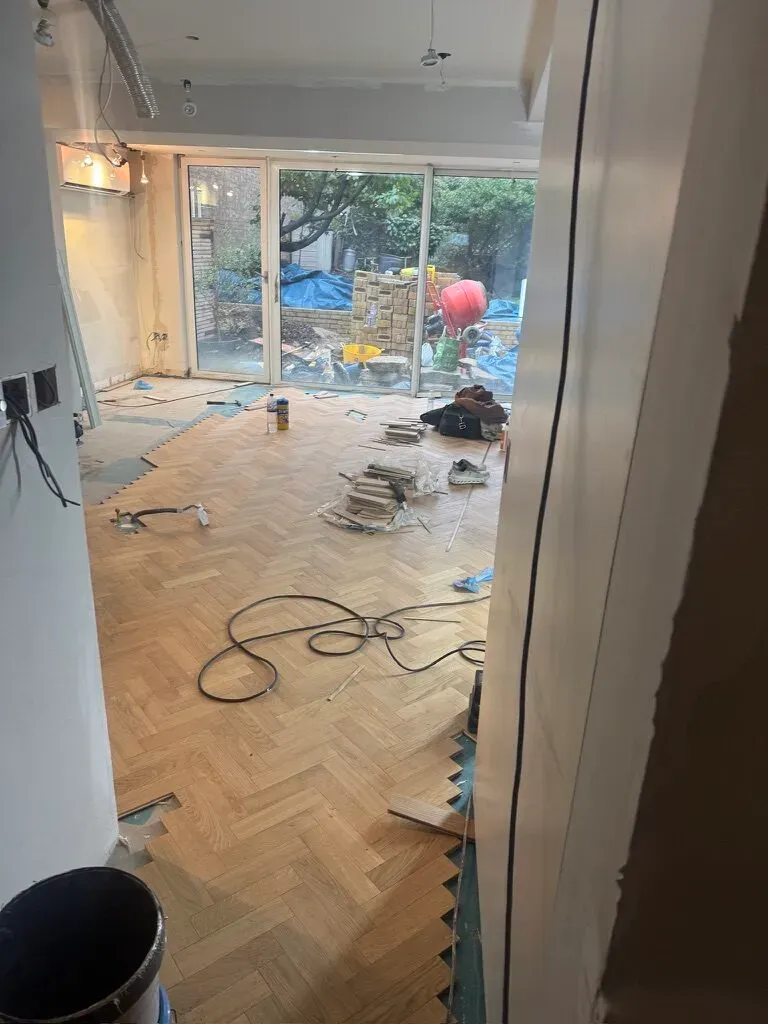 New herringbone timber flooring being laid through the renovated period house