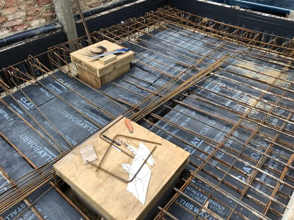 Steel reinforcement and slab insulation laid out over the foundations of a new-build house in Wandsworth